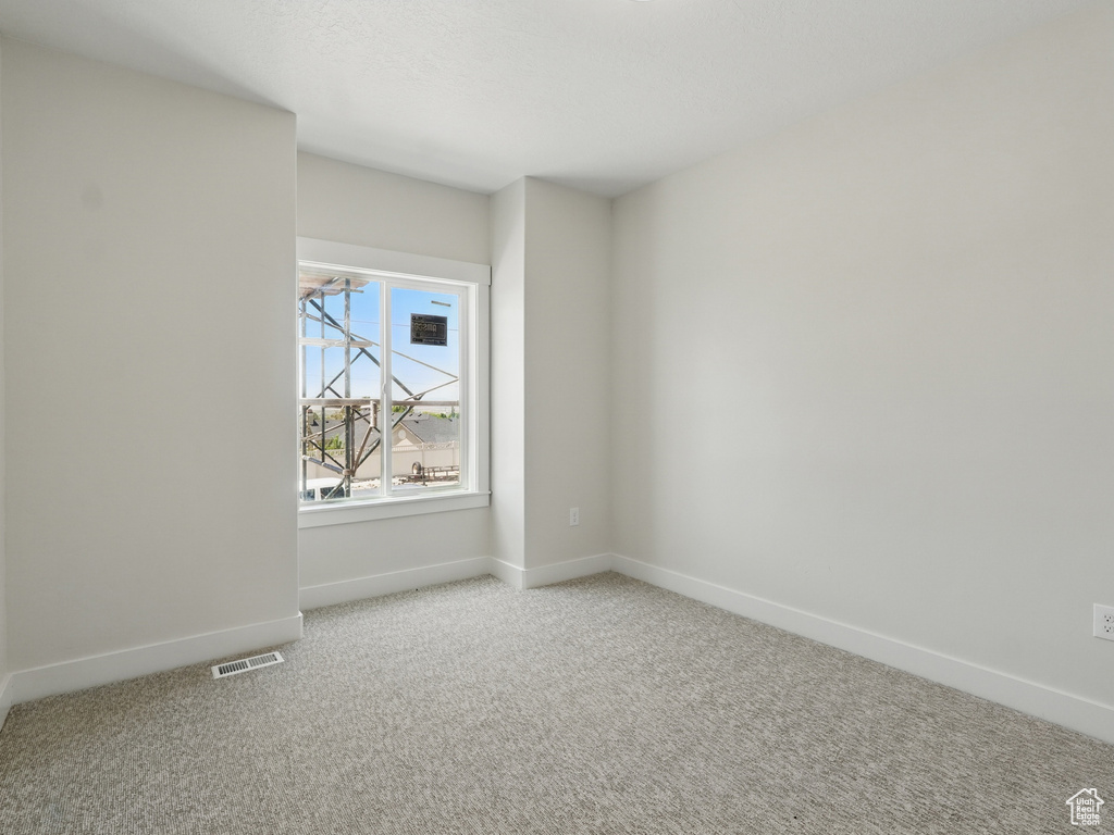 Empty room with baseboards and carpet