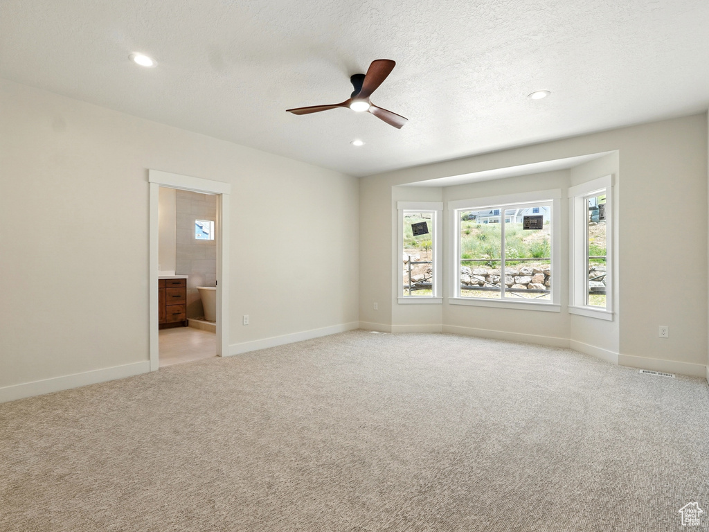 Empty room featuring a ceiling fan, light colored carpet, baseboards, recessed lighting, and a textured ceiling
