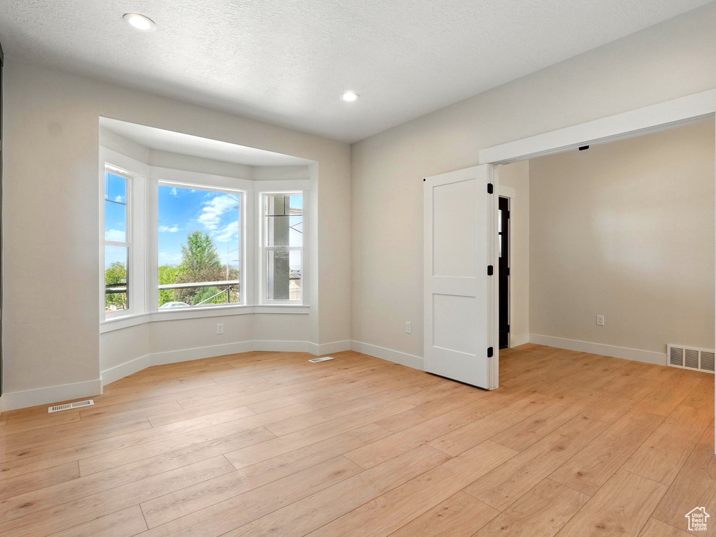 Unfurnished room featuring baseboards, light wood-style floors, and recessed lighting