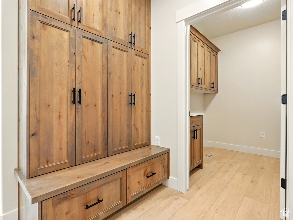 Mudroom featuring light wood-style floors and baseboards