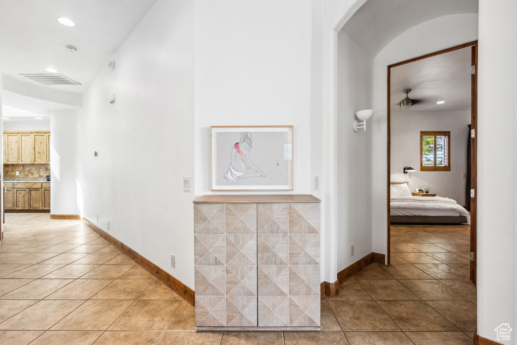 Hall with light tile patterned floors, recessed lighting, and baseboards