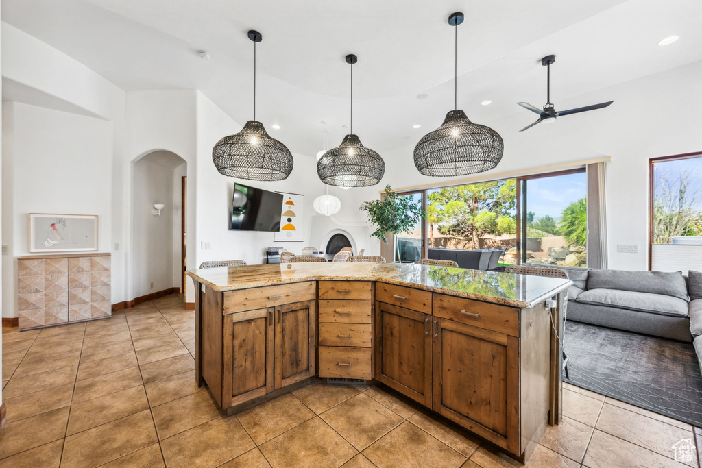 Kitchen featuring open floor plan, arched walkways, recessed lighting, light tile patterned floors, and ceiling fan