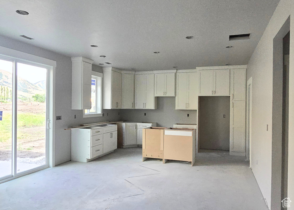 Kitchen with concrete floors and white cabinets