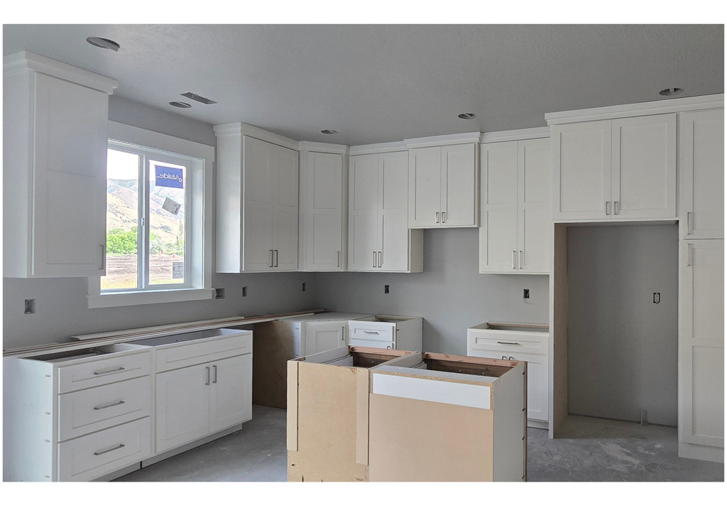 Kitchen featuring a kitchen island and white cabinetry