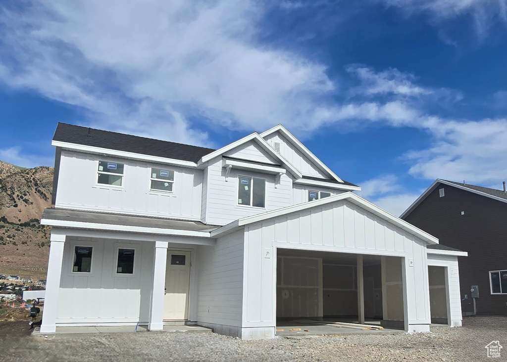 View of front facade with board and batten siding, covered porch, and a mountain view
