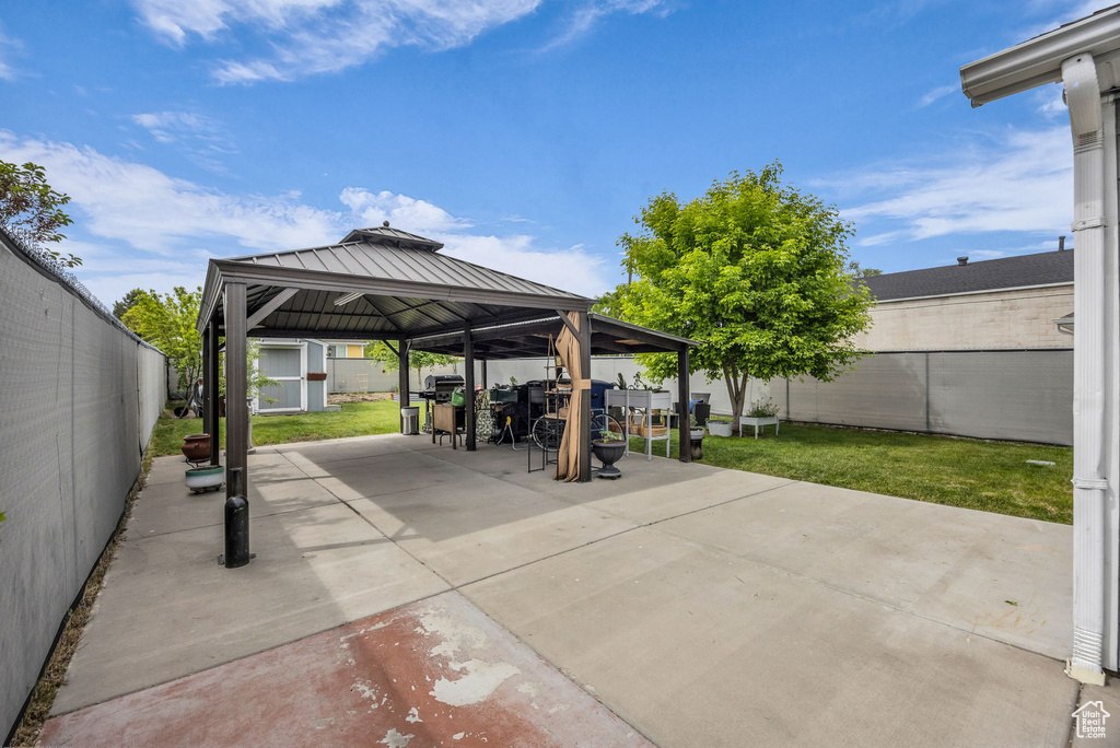View of patio with a gazebo, outdoor dining space, and a grill