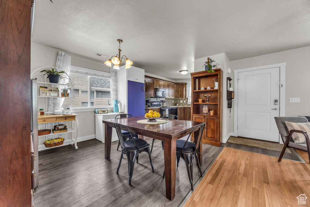 Dining room with a chandelier, light wood-type flooring, and baseboards