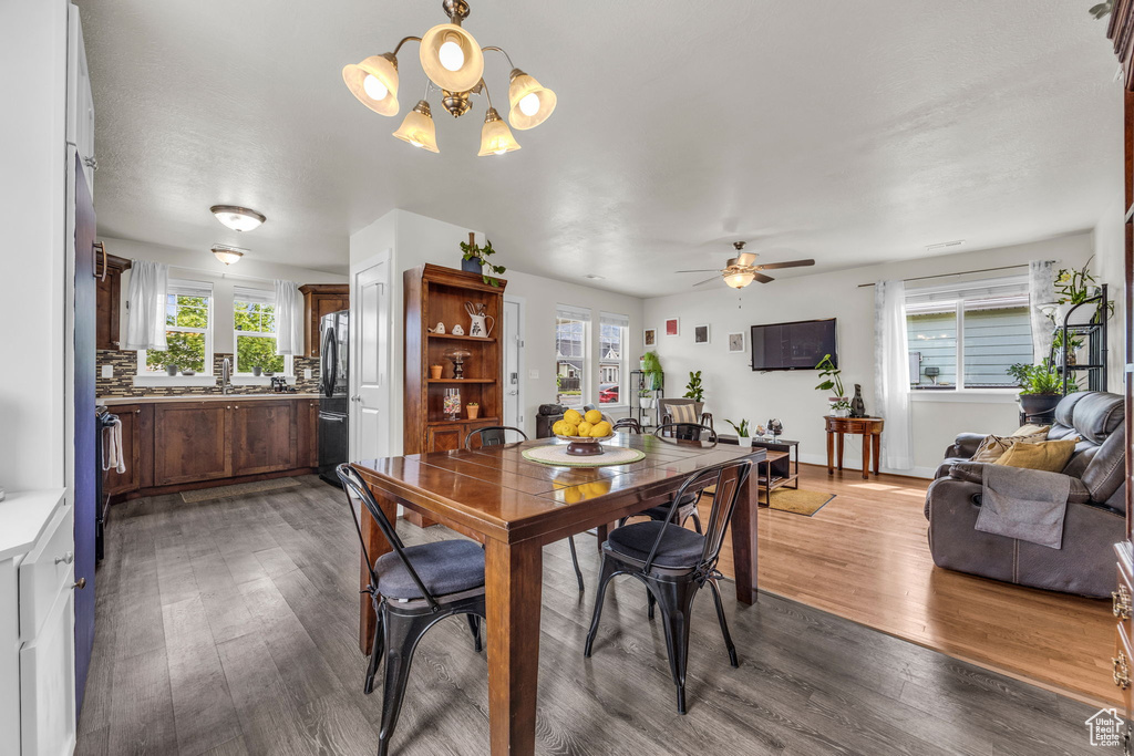 Dining space with plenty of natural light, wood finished floors, and a chandelier