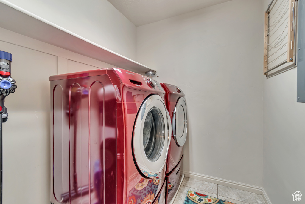 Laundry area featuring independent washer and dryer, baseboards, and tile patterned flooring