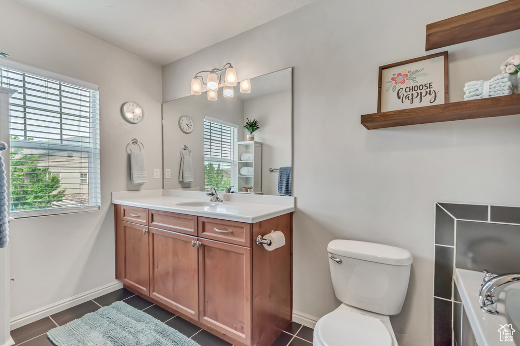 Full bath with vanity, a garden tub, toilet, tile patterned floors, and baseboards