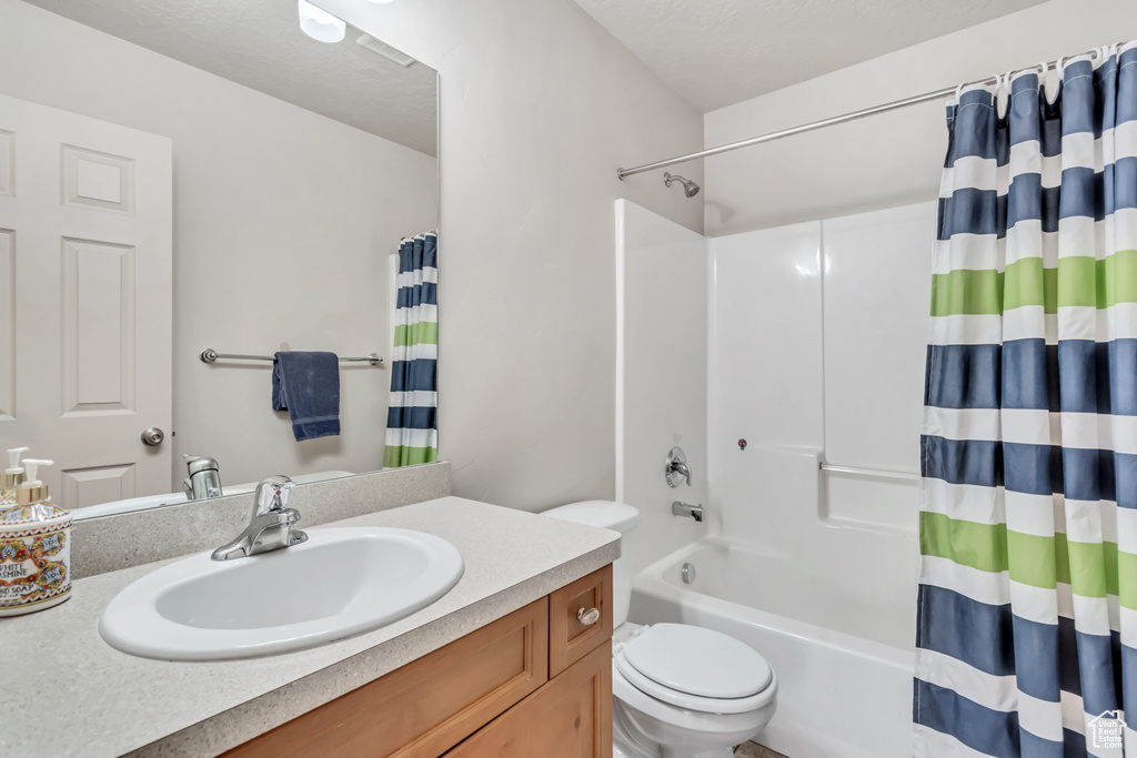 Full bathroom with vanity, toilet, and shower / tub combo