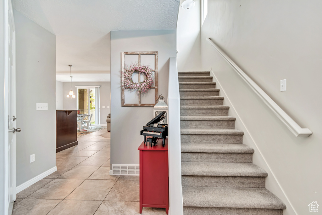 Staircase with tile patterned flooring and baseboards