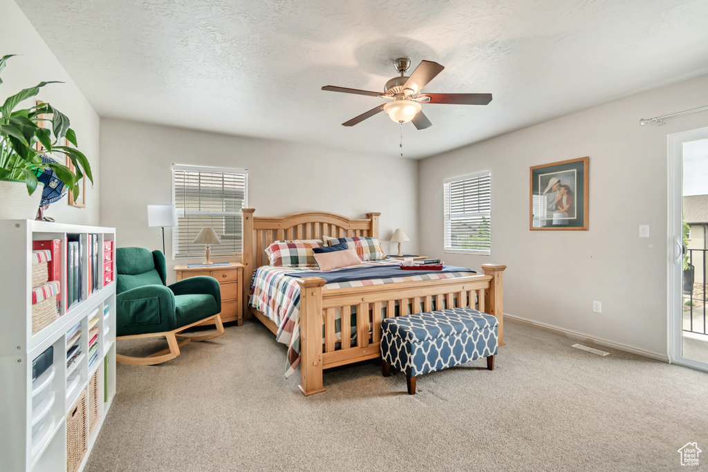 Bedroom featuring multiple windows and light carpet