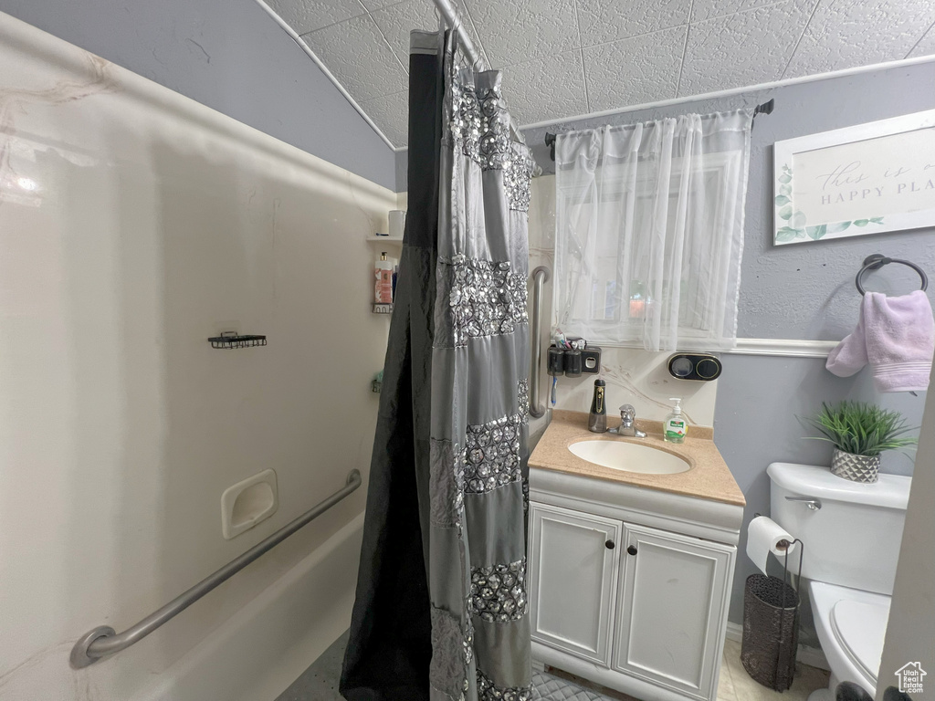 Full bathroom with vanity, toilet, and shower / bath combo with shower curtain