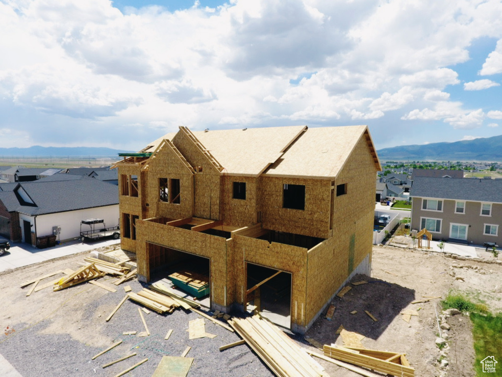 Back of property featuring a garage, a mountain view, and a residential view