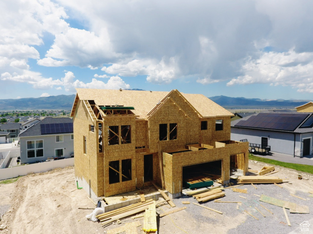 View of front facade with a mountain view, a garage, and a residential view