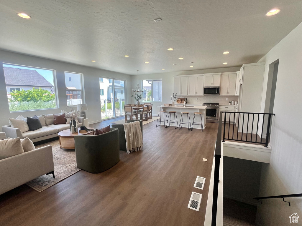 Living room featuring dark wood-style flooring and recessed lighting