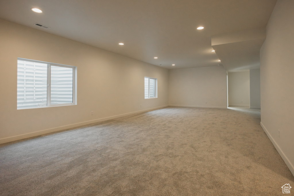 Empty room with light carpet, recessed lighting, and baseboards