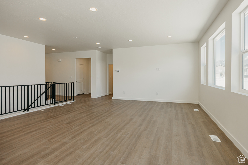 Empty room featuring light wood finished floors, recessed lighting, and baseboards
