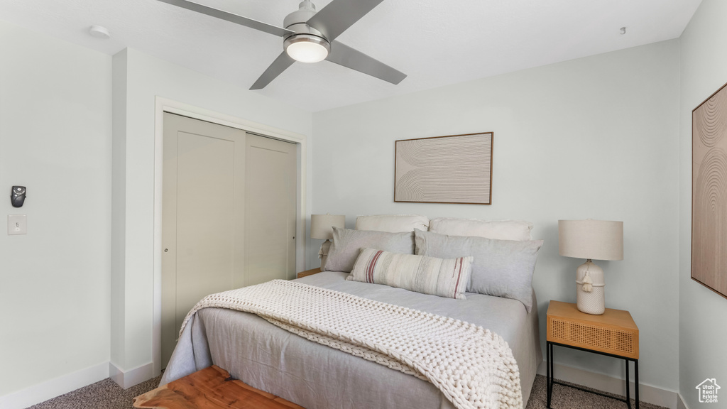Carpeted bedroom with baseboards, a closet, and ceiling fan