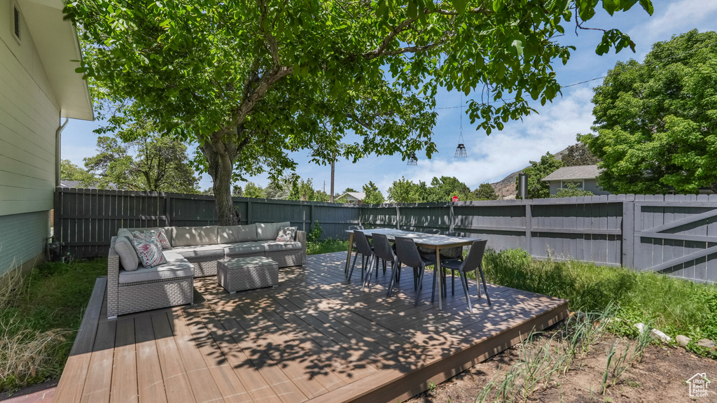 Wooden terrace featuring an outdoor hangout area, a fenced backyard, and outdoor dining area