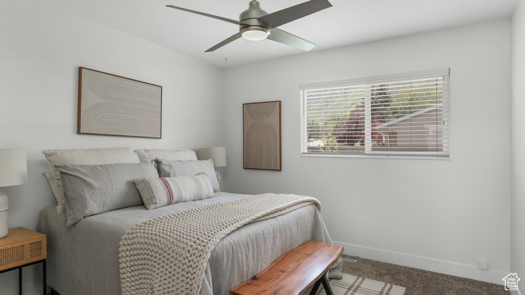 Carpeted bedroom with baseboards and a ceiling fan