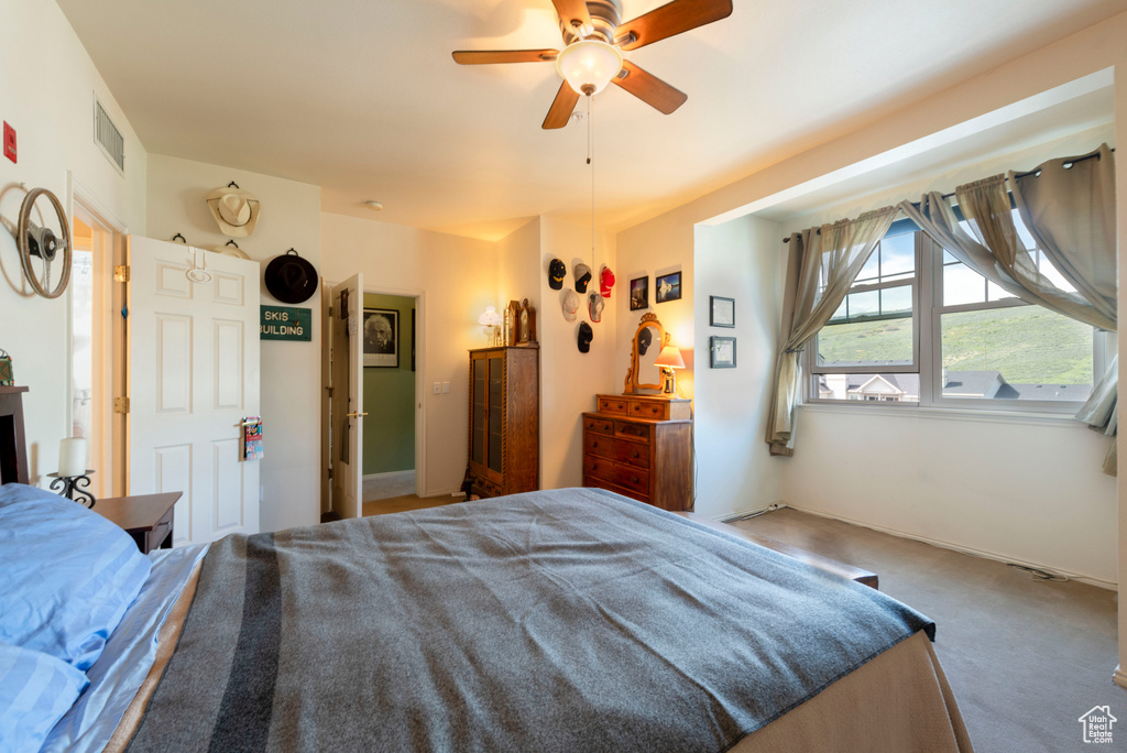 Carpeted bedroom with a ceiling fan