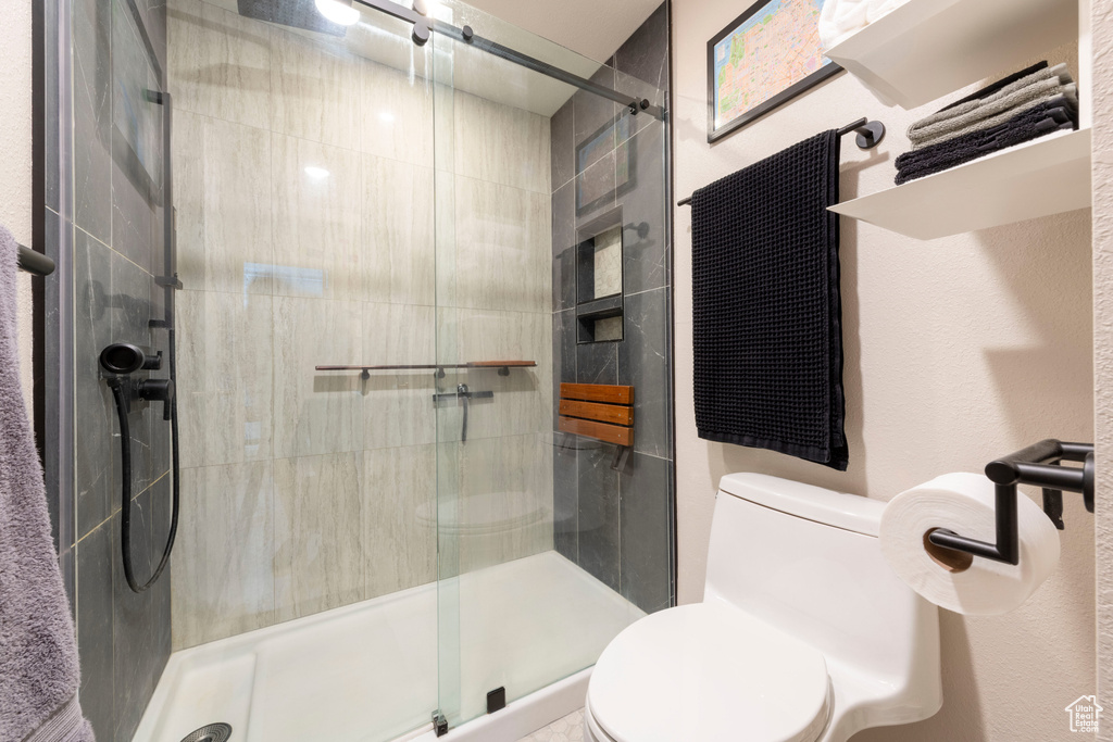 Bathroom featuring toilet and a stall shower