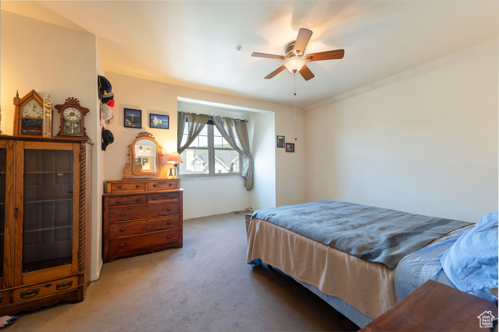 Carpeted bedroom featuring a ceiling fan