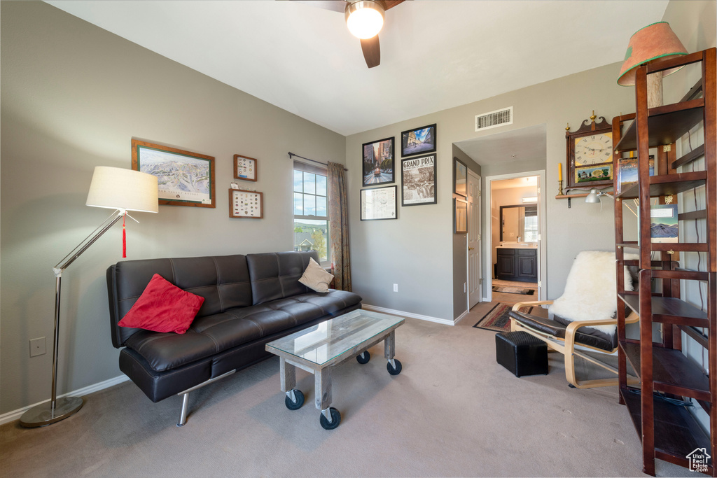 Living area with carpet flooring, ceiling fan, and baseboards