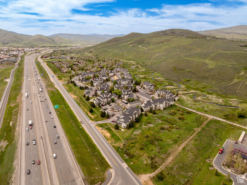 Aerial view of property\'s location with a highway, a mountainous background, and nearby suburban area