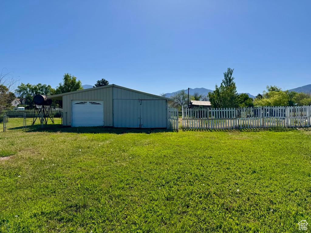 View of yard featuring a detached garage, an outbuilding, and a mountain view