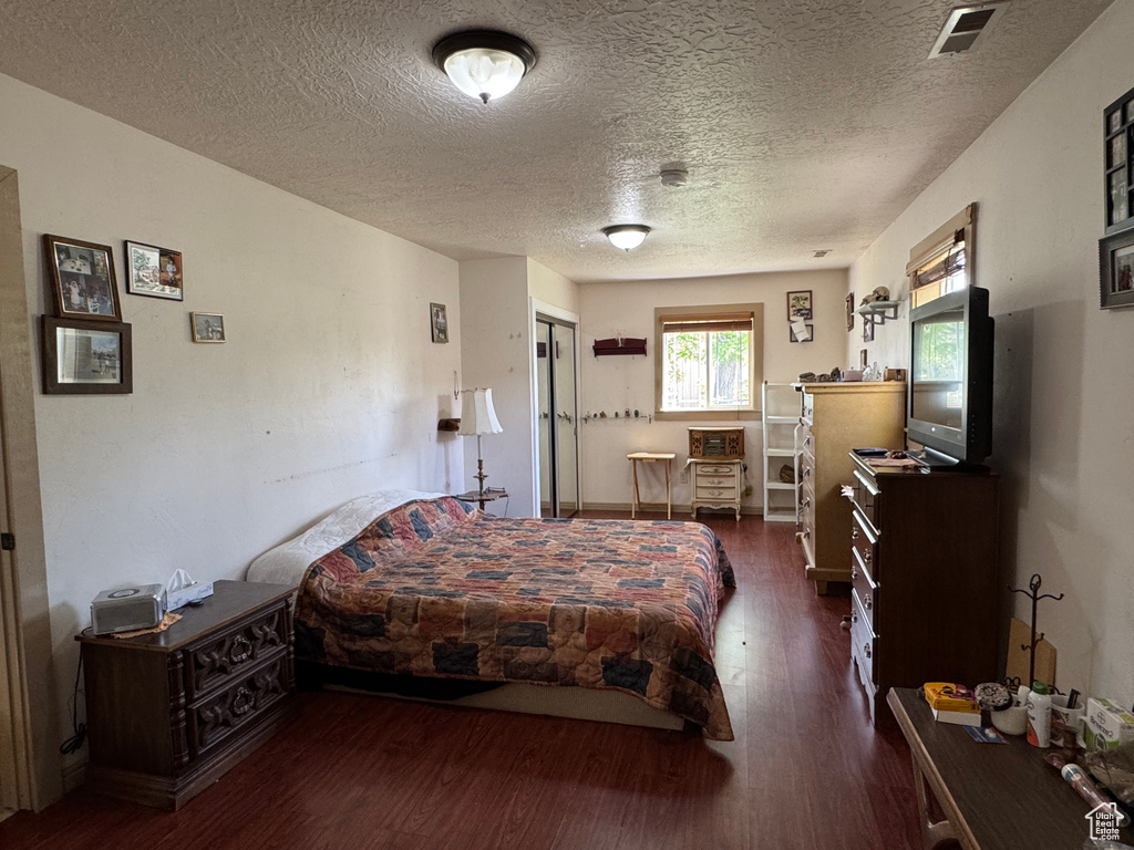 Bedroom with wood finished floors and a textured ceiling