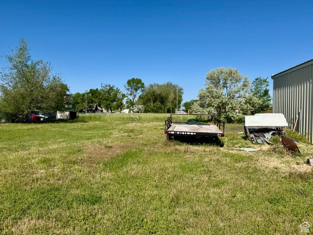 View of grassy yard featuring a deck