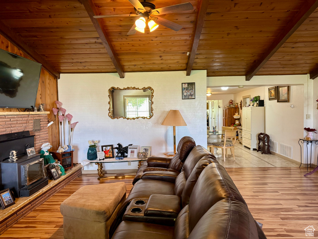 Living area featuring a ceiling fan, wood finished floors, wood ceiling, and baseboards