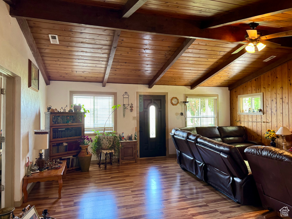 Living area featuring wood finished floors, wood ceiling, ceiling fan, and wood walls
