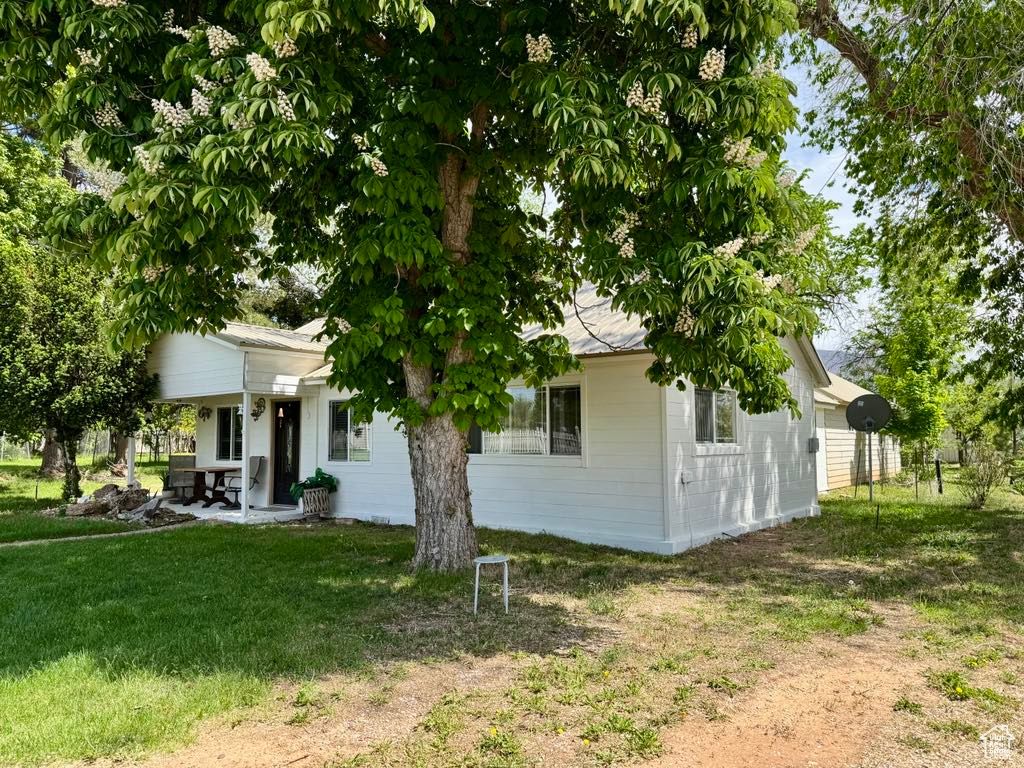 View of front facade with covered porch and a front lawn