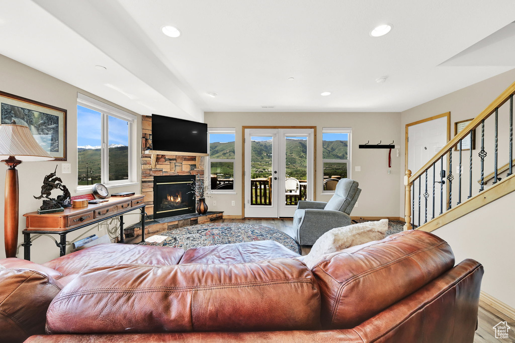 Living room with french doors, wood finished floors, baseboards, recessed lighting, and stairway
