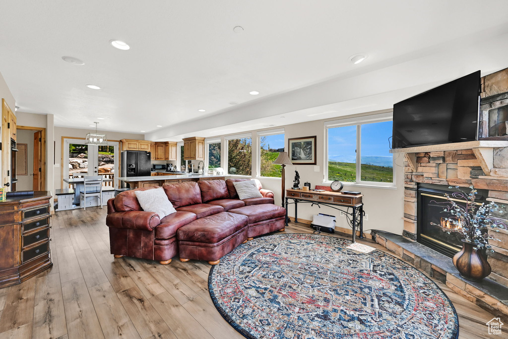Living area with plenty of natural light, light wood-type flooring, a fireplace, and recessed lighting