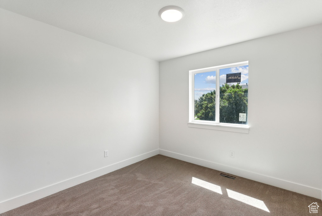 Carpeted empty room with baseboards