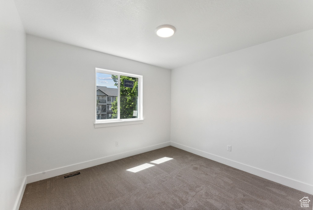 Carpeted empty room featuring baseboards