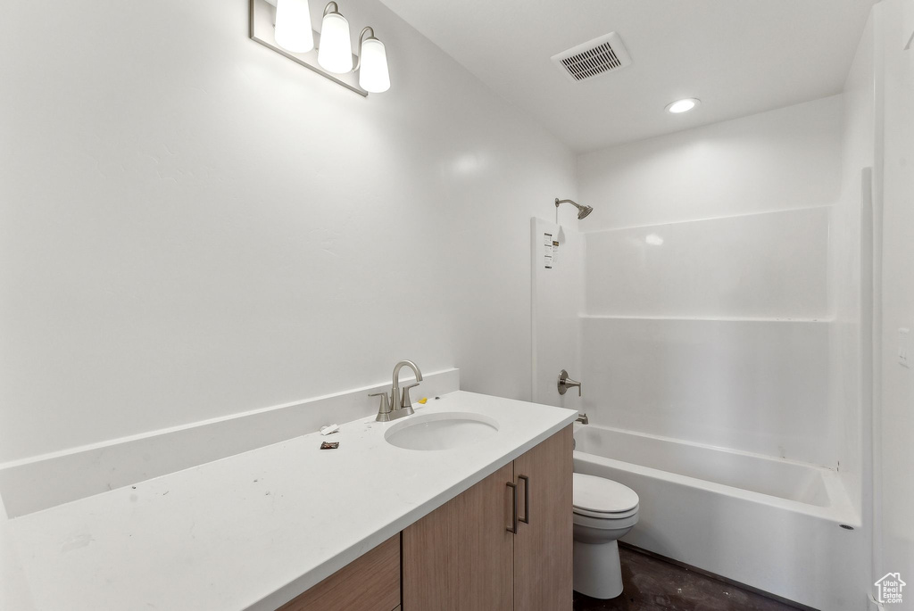 Bathroom with toilet, vanity, and  shower combination