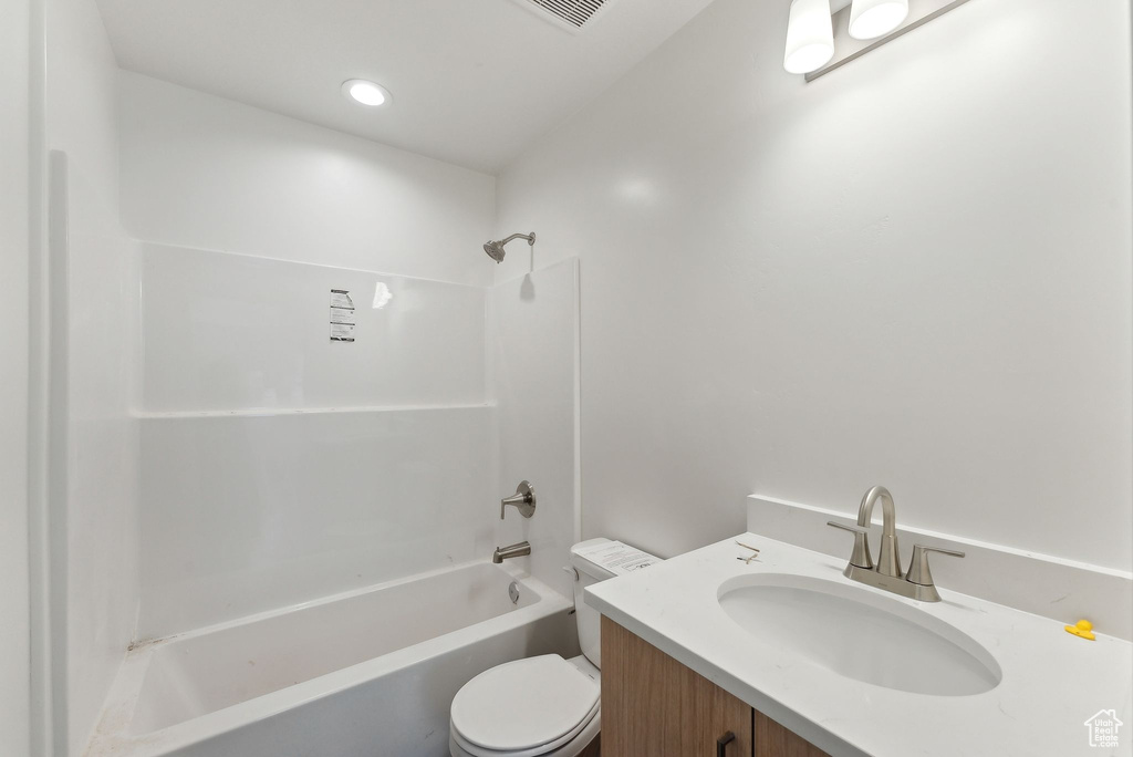Full bathroom featuring toilet, shower / bath combination, and vanity