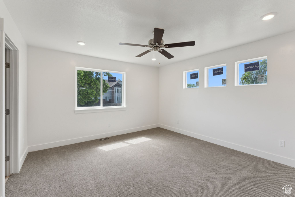 Unfurnished room with healthy amount of natural light, carpet floors, baseboards, and recessed lighting