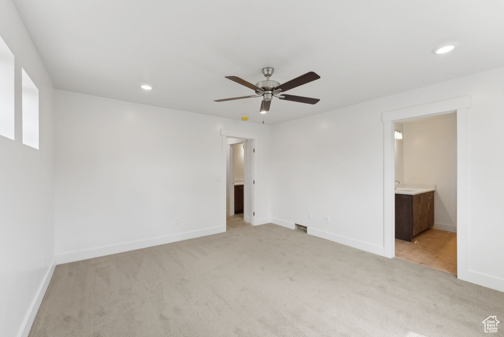 Unfurnished bedroom with light colored carpet, baseboards, recessed lighting, ensuite bath, and a ceiling fan