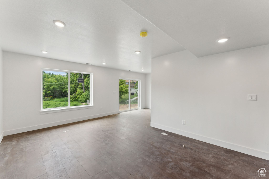 Unfurnished room featuring baseboards, recessed lighting, and dark wood-style flooring