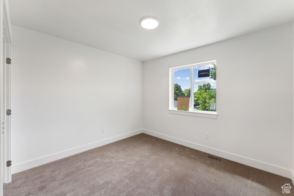Unfurnished room featuring carpet floors and baseboards