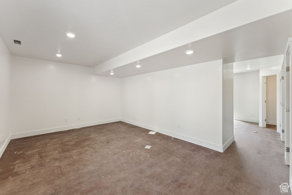Unfurnished room featuring concrete flooring, baseboards, and recessed lighting