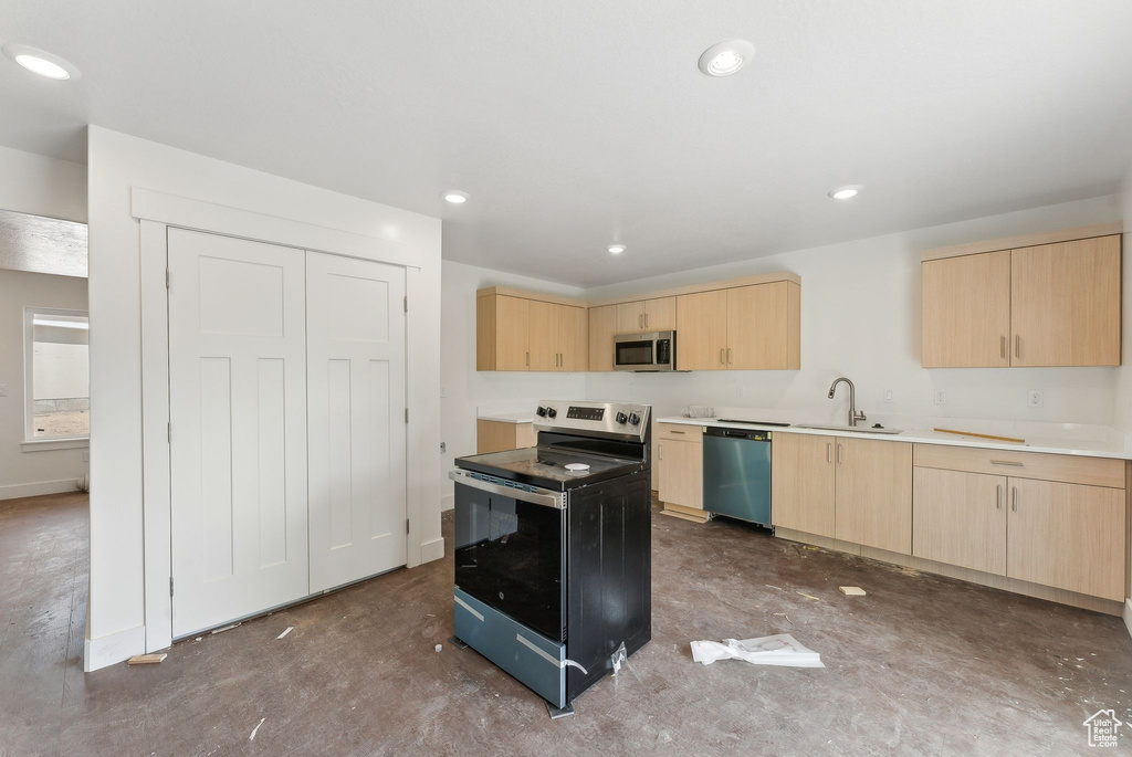 Kitchen with light brown cabinets, stainless steel appliances, a sink, concrete flooring, and recessed lighting