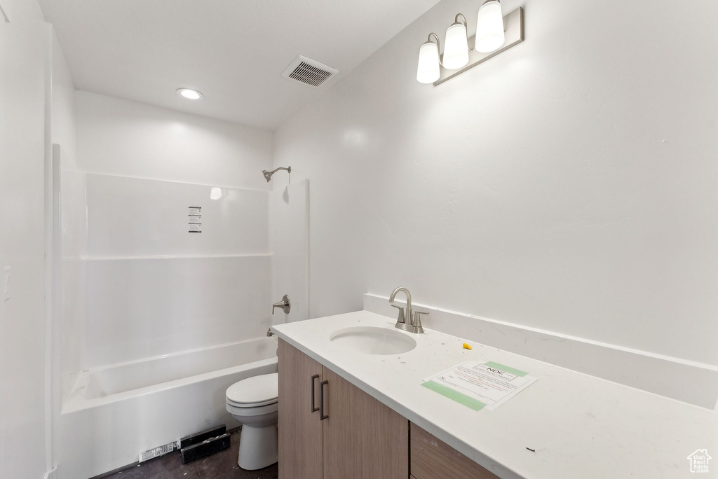 Bathroom with toilet, vanity, and  shower combination
